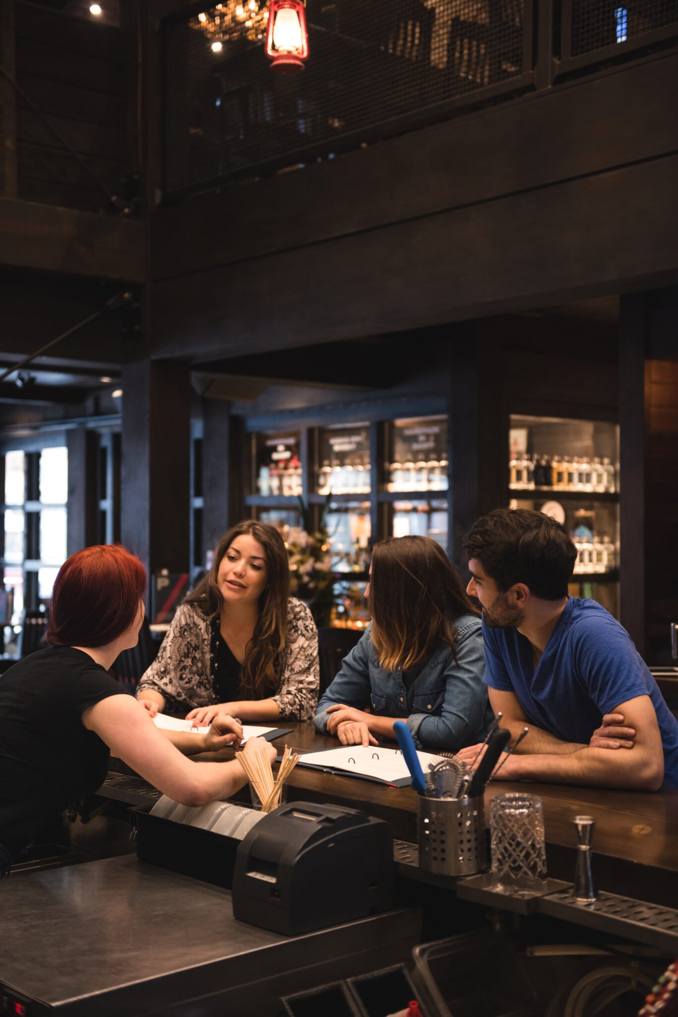 Bartender interacting with customers at bar counter